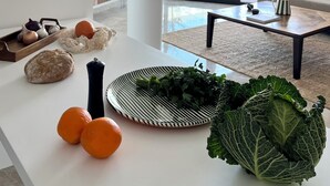 Ein modernes Wohnzimmer mit einem weißen Couchtisch, einer Couch und einem großen Fenster.