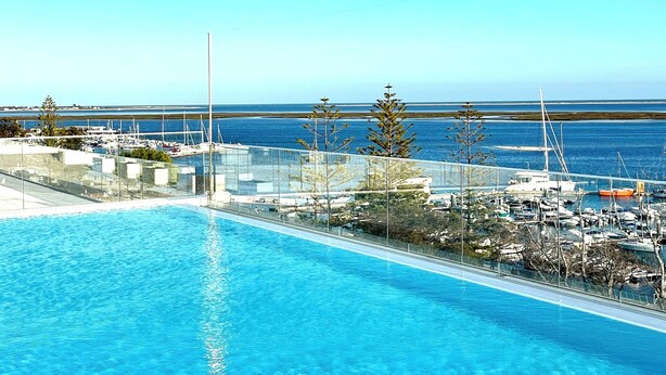 A clear blue swimming pool with a view of the marina and boats in the background. - Luz do Mar 1 - Olhão, Algarve (Olhão)