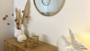 A wooden console table with decorative items, a round mirror, and a wall clock. - Luz Marina - Olhão, Algarve (Olhão)
