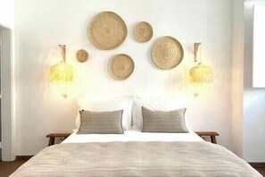 A bedroom with a bed, two bedside tables, and wall-mounted lamps. - Luz Harmonia - Olhão, Algarve (Olhão)