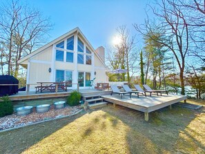Uma casa moderna com um deck, área de estar externa e piscina.