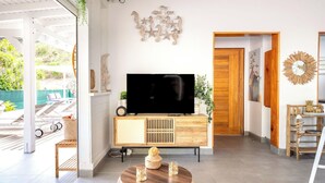 Una sala de estar moderna con televisor de pantalla plana, mueble de madera y decoración de pared.