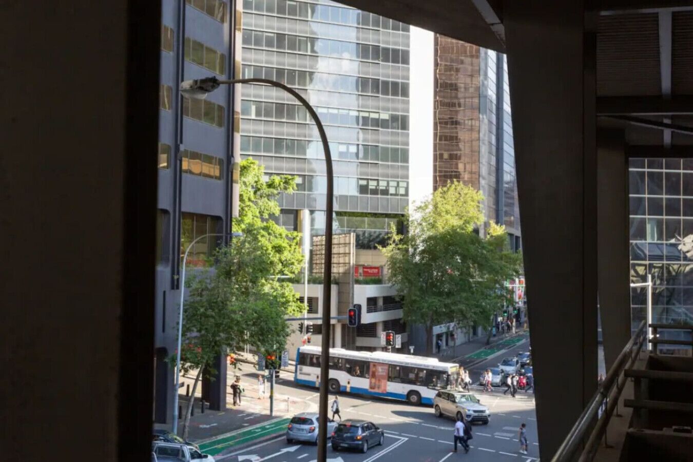 A view of a city street with buildings, a bus, and cars.