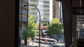A view of a city street with buildings, a bus, and cars.