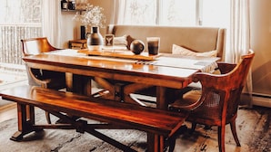 A dining area with a wooden table, benches, and a chandelier. - Charming 4 bedroom home in beautiful Missoula w/ great proximity to all the fun! (Missoula)
