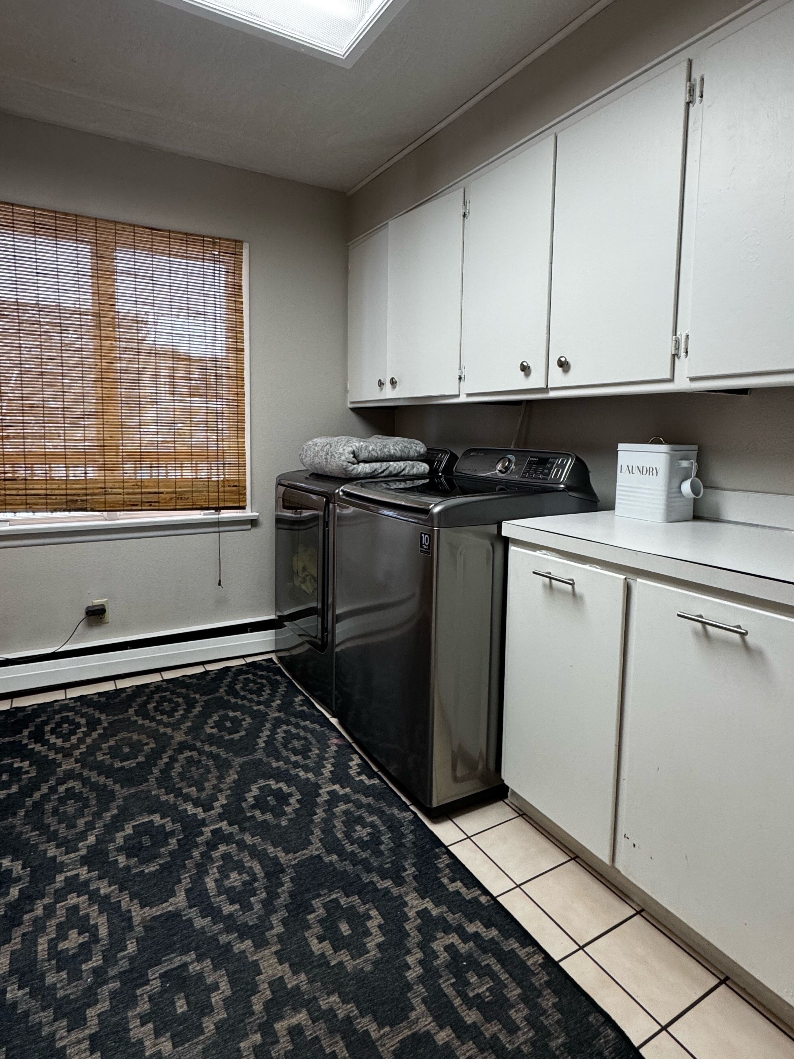 A compact kitchen with a washing machine, a refrigerator, and a coffee maker.