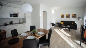 A modern apartment with a kitchen, dining area, and living room.