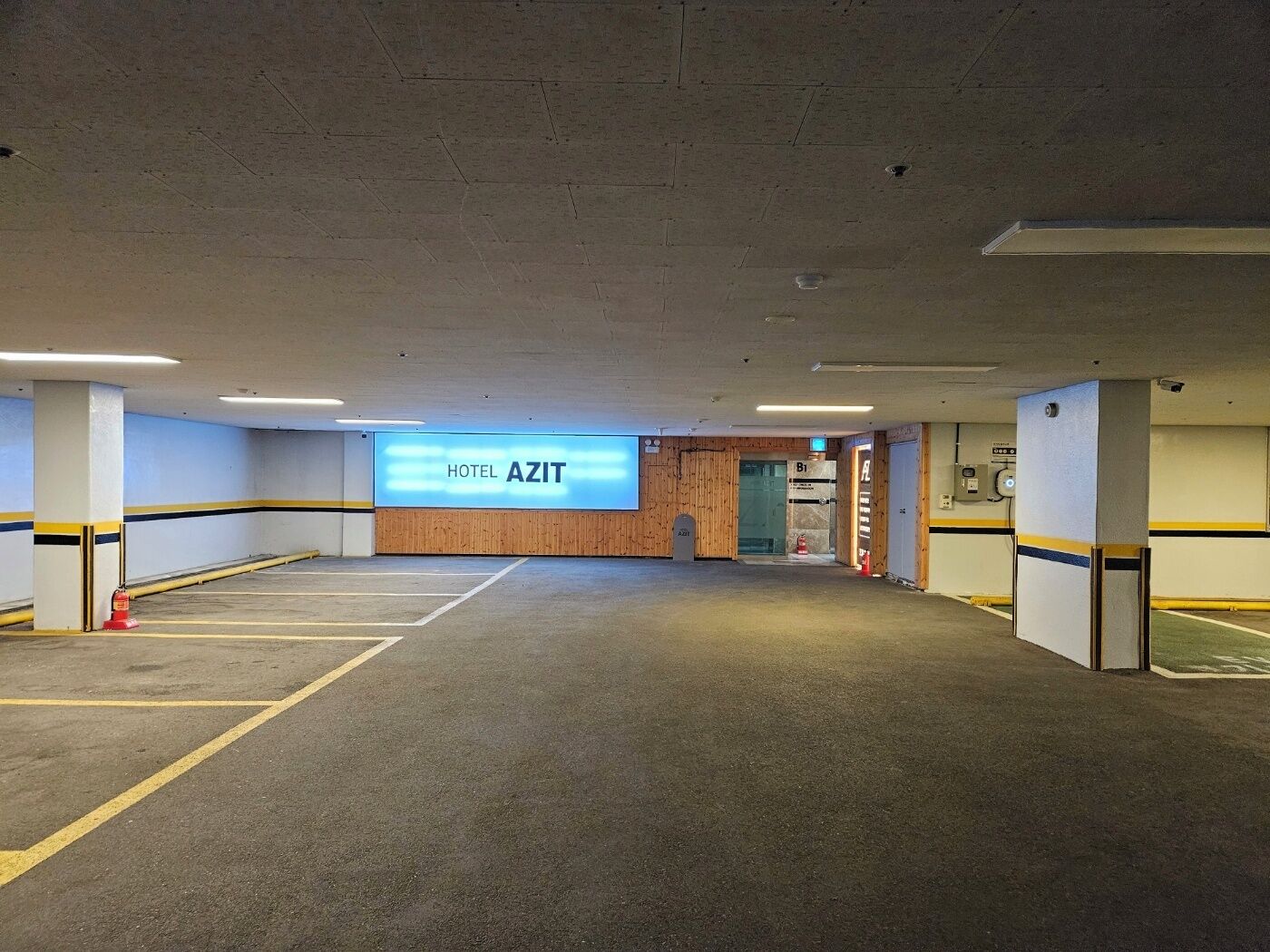 Un amplio estacionamiento con un letrero que indica Hotel Azit.