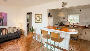 A spacious living area with a sofa, a coffee table, and a dining area with a bar. - Casa de Conejito: Comfy Marfa Retreat (Marfa)