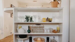A white shelf with various glassware and kitchen items. - Casa de Conejito: Comfy Marfa Retreat (Marfa)