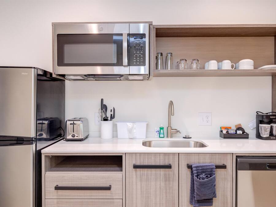 Una cocina compacta equipada con microondas, tostadora, fregadero y lavavajillas.