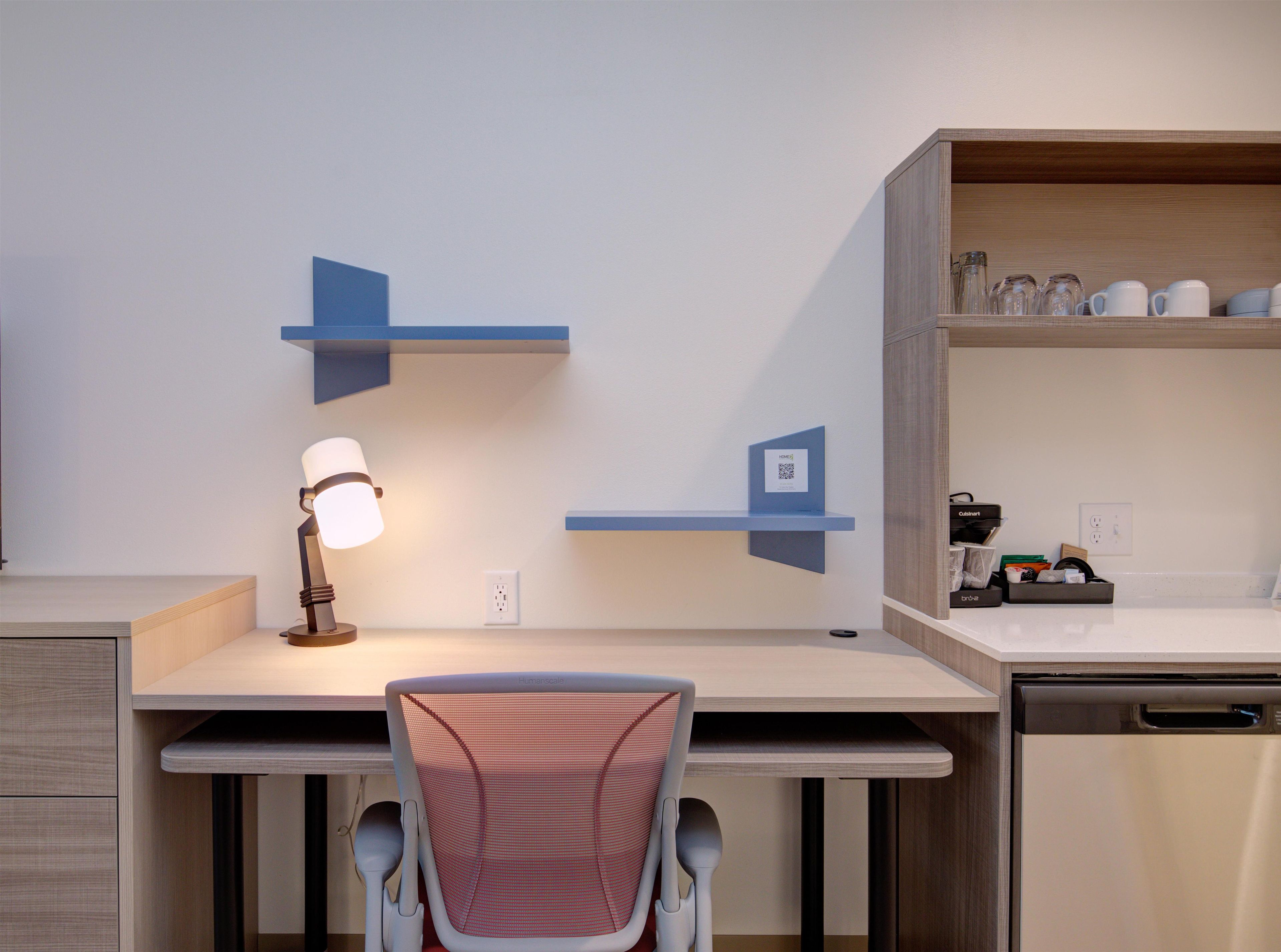 Una cocina moderna con lavavajillas incorporado, cafetera y estante con utensilios de cocina.