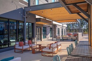 Un área de patio al aire libre con disposición de asientos y vistas de los edificios circundantes.