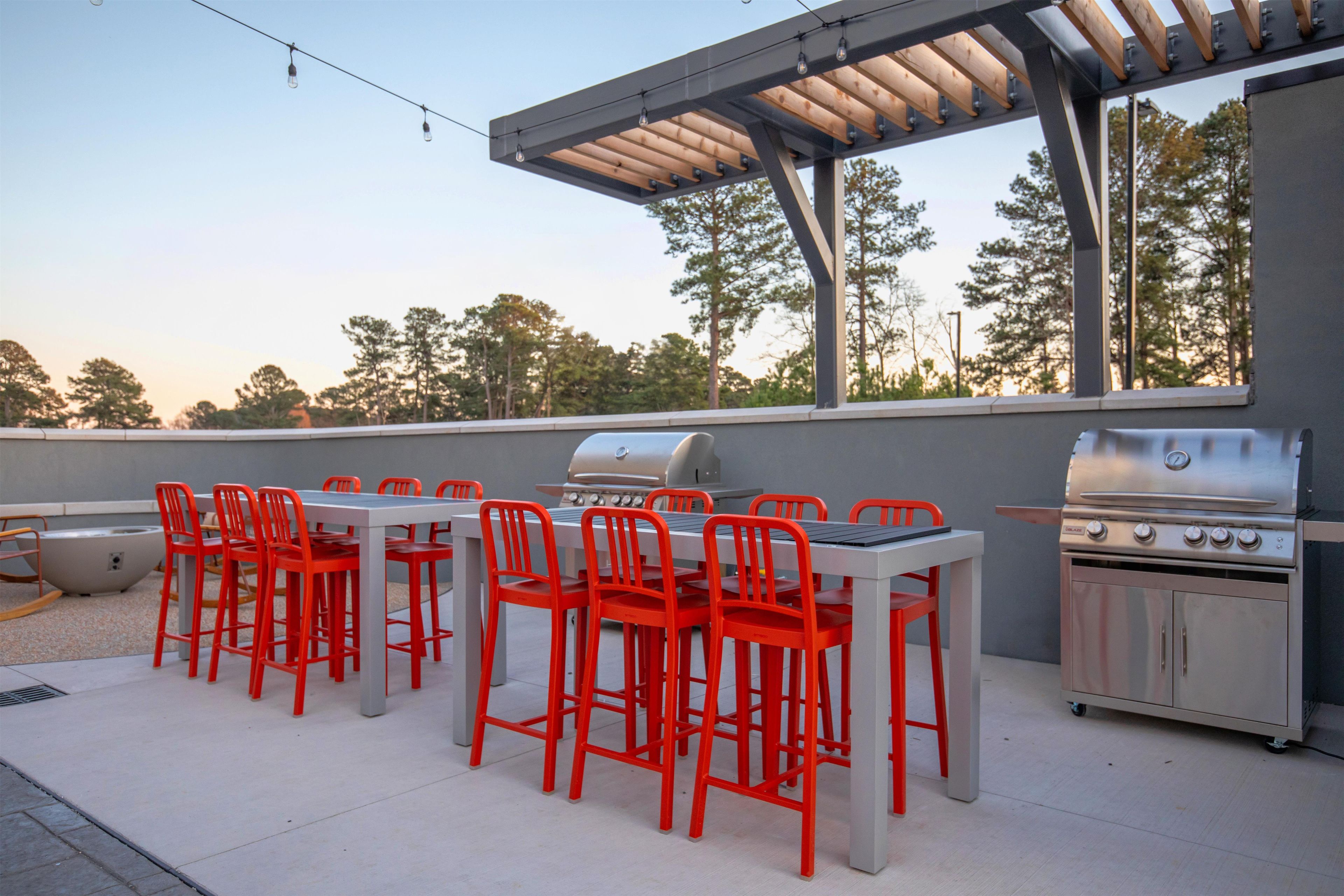 Un patio exterior con una parrilla y zona de estar.