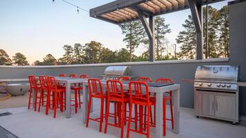 Un patio exterior con una parrilla y zona de estar.
