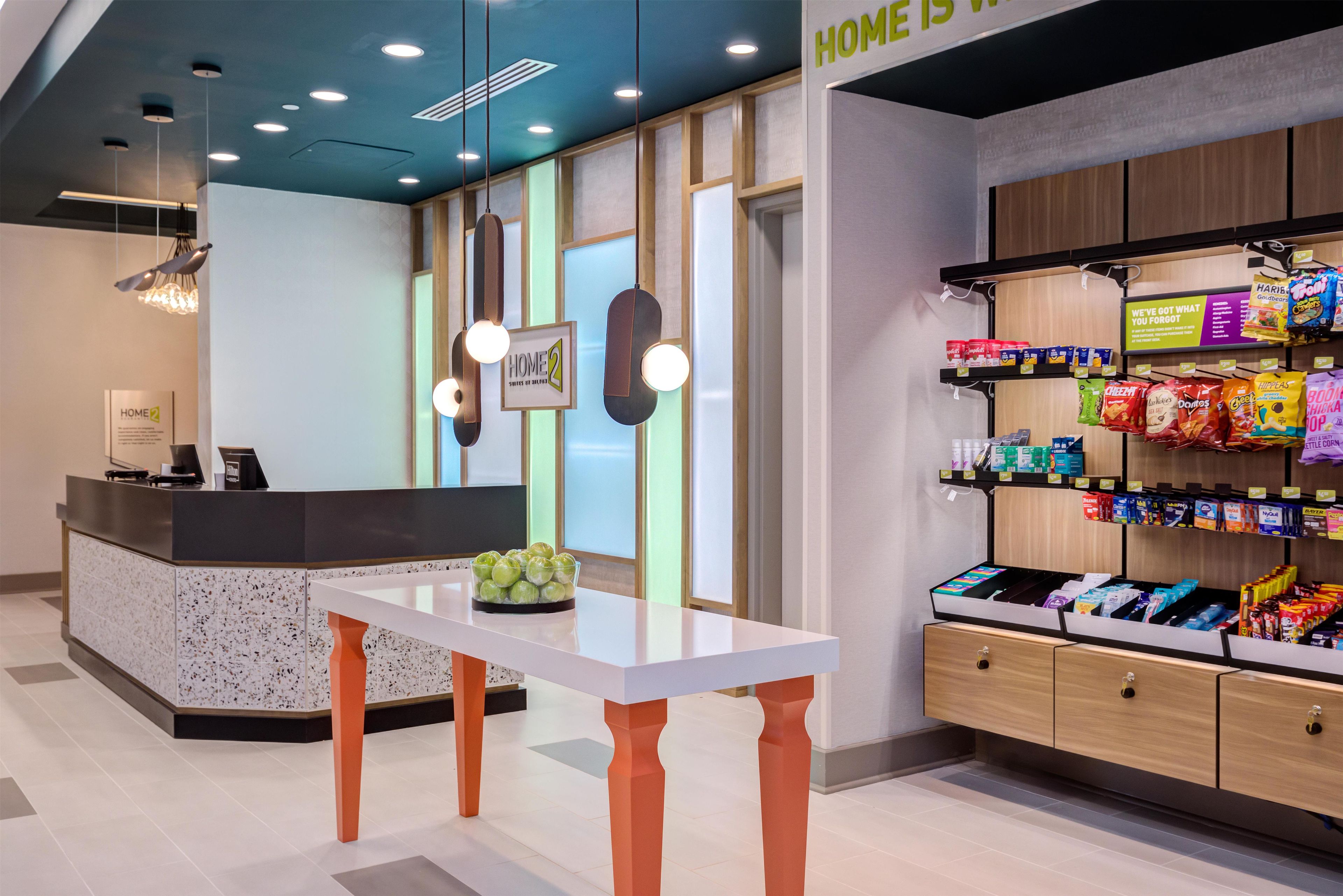 A reception area with a counter, a sign reading 'HOME 2', and a snack display.