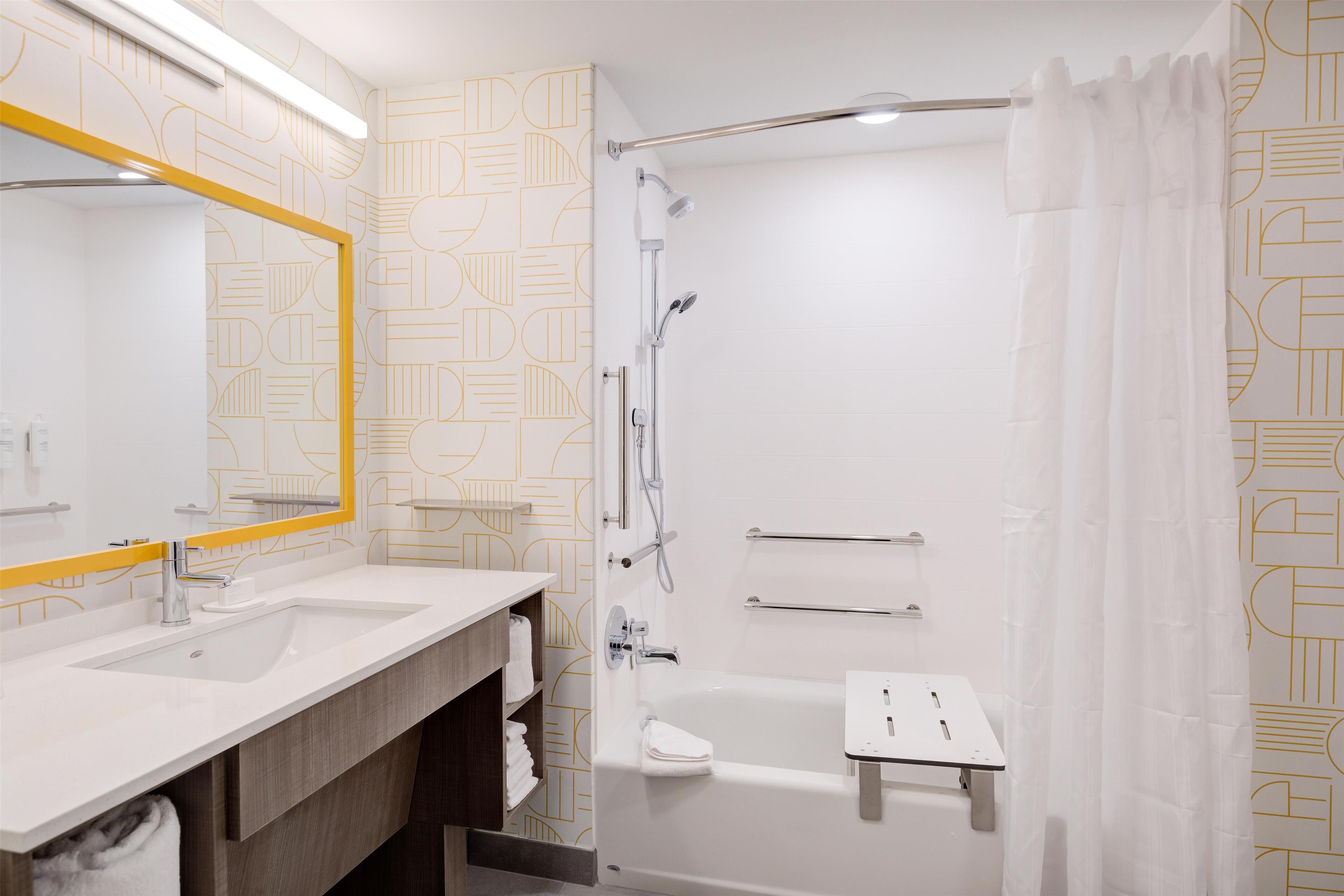 Een moderne badkamer met twee wastafels, een grote spiegel, een douche en een bad.
