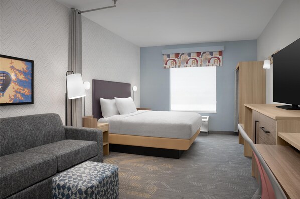 A modern hotel room with a bed, a sofa, a desk, and a TV. - Home2 Suites By Hilton Rohnert Park Sonoma County (Rohnert Park)