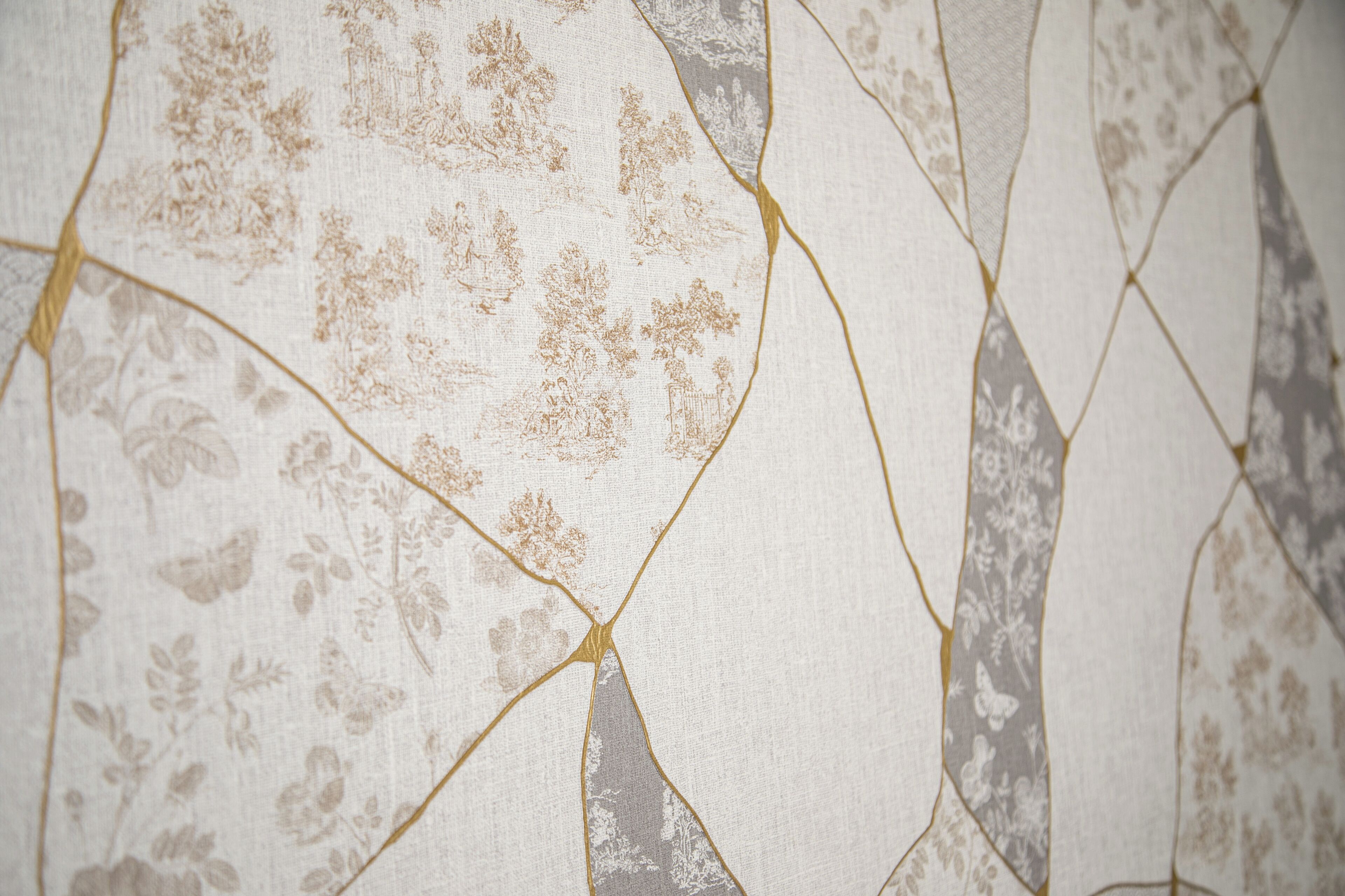 A close-up of a wallpaper with a floral pattern and a cracked texture.