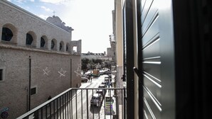 A view from a balcony overlooking a street with a historic building featuring arched windows and a bell tower. - Dimora Amelia Apartment 2, spacious apartment tastefully finished. (Bitonto)