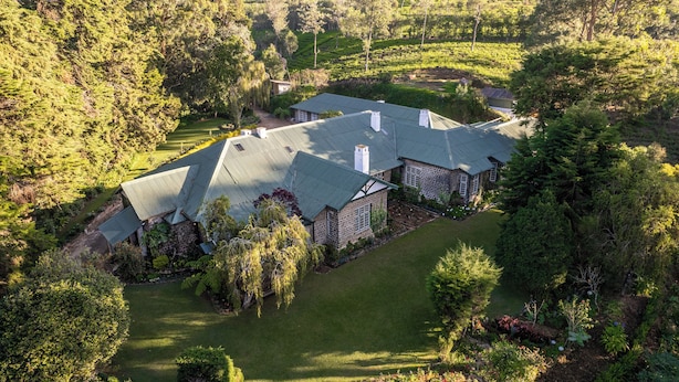 A large, stone house with a green roof, surrounded by lush greenery and a well-maintained lawn. - Bluechip Leisure Summerhill Bungalow (Nuwara Eliya)
