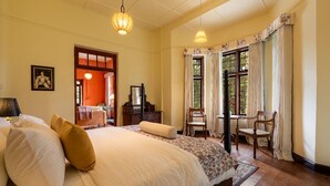 A hotel room with a large bed, two chairs, a desk, and a window with curtains. - Bluechip Leisure Summerhill Bungalow (Nuwara Eliya)