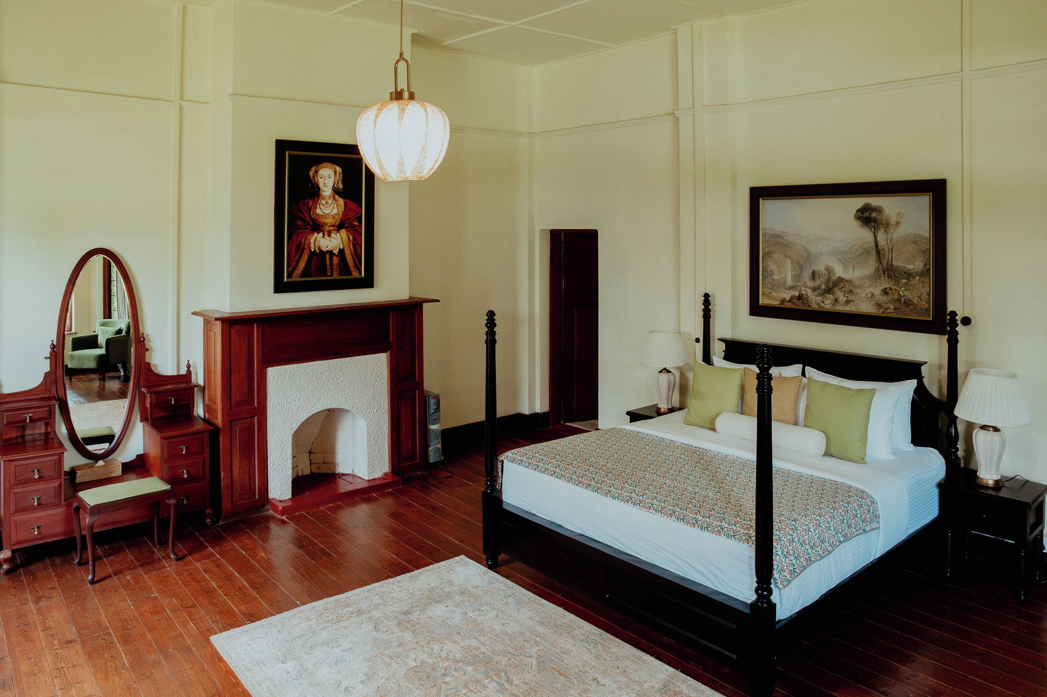 Un dormitorio con cama con dosel, chimenea, espejo y obras de arte en las paredes.