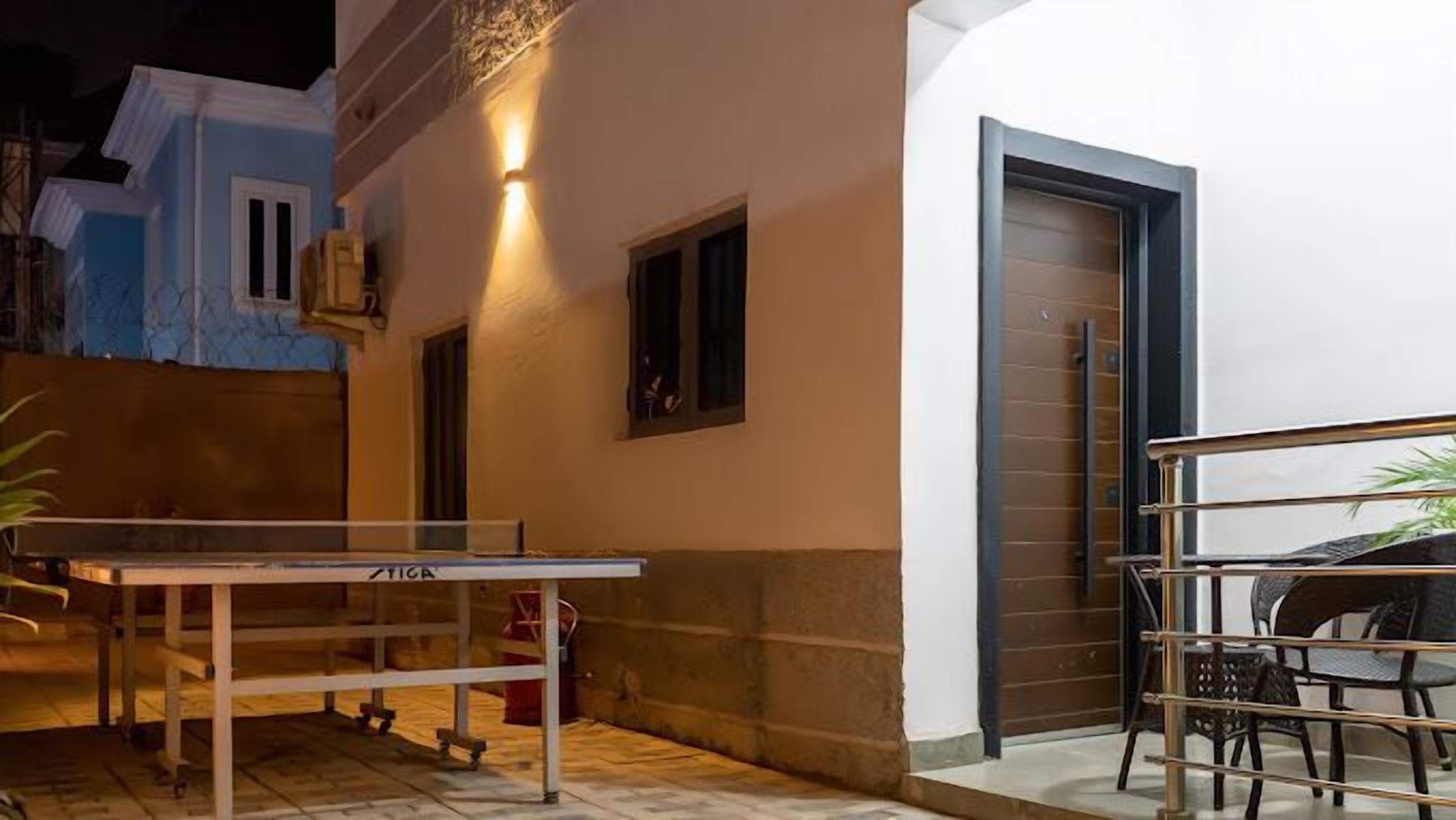 Un espace extérieur comprenant une table de ping-pong, une chaise et une petite table.
