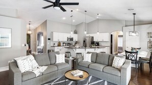 A modern living room with a gray sectional sofa, a coffee table, and a black and white patterned rug. - Heated Pool at Turtle Cove Sleeps 12 (Mesquite)