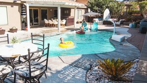A backyard with a swimming pool, outdoor seating, and a covered patio area. - Heated Pool at Turtle Cove Sleeps 12 (Mesquite)