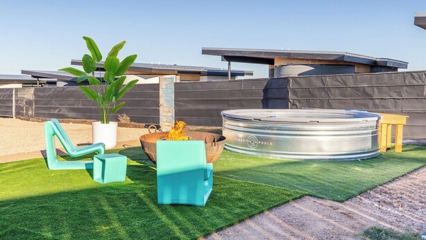 A rooftop patio with a fire pit, a hot tub, and outdoor furniture. - RV Spot #5 @ The Halles (Round Top)