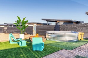 A rooftop patio with a fire pit, a hot tub, and outdoor furniture.
