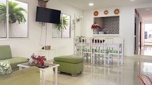 A modern waiting area with green seating, a flat-screen TV, and a tiled backsplash. - Private house with pool - Riohacha, La Guajira. Colombia (Riohacha)