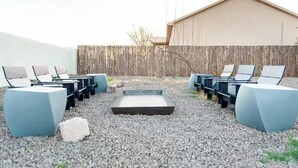 Een terras met zitplaatsen en een vuurkorf.