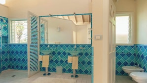 A bathroom with two sinks, a mirror, and a toilet. - Villa Tramonto. Great view, pool, exclusive area and beach at walking distance. (St. Johns)