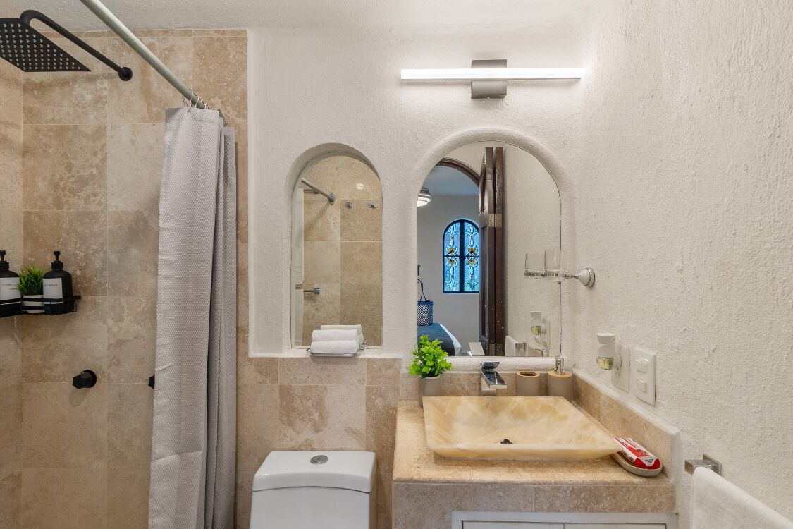 Une salle de bain moderne avec un lavabo beige, une douche et un miroir.