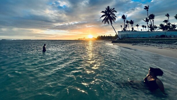 A beach with palm trees and a sunset. - Cozy 3-bedroom house in peaceful Juan Dolio with WiFi, AC (Juan Dolio)