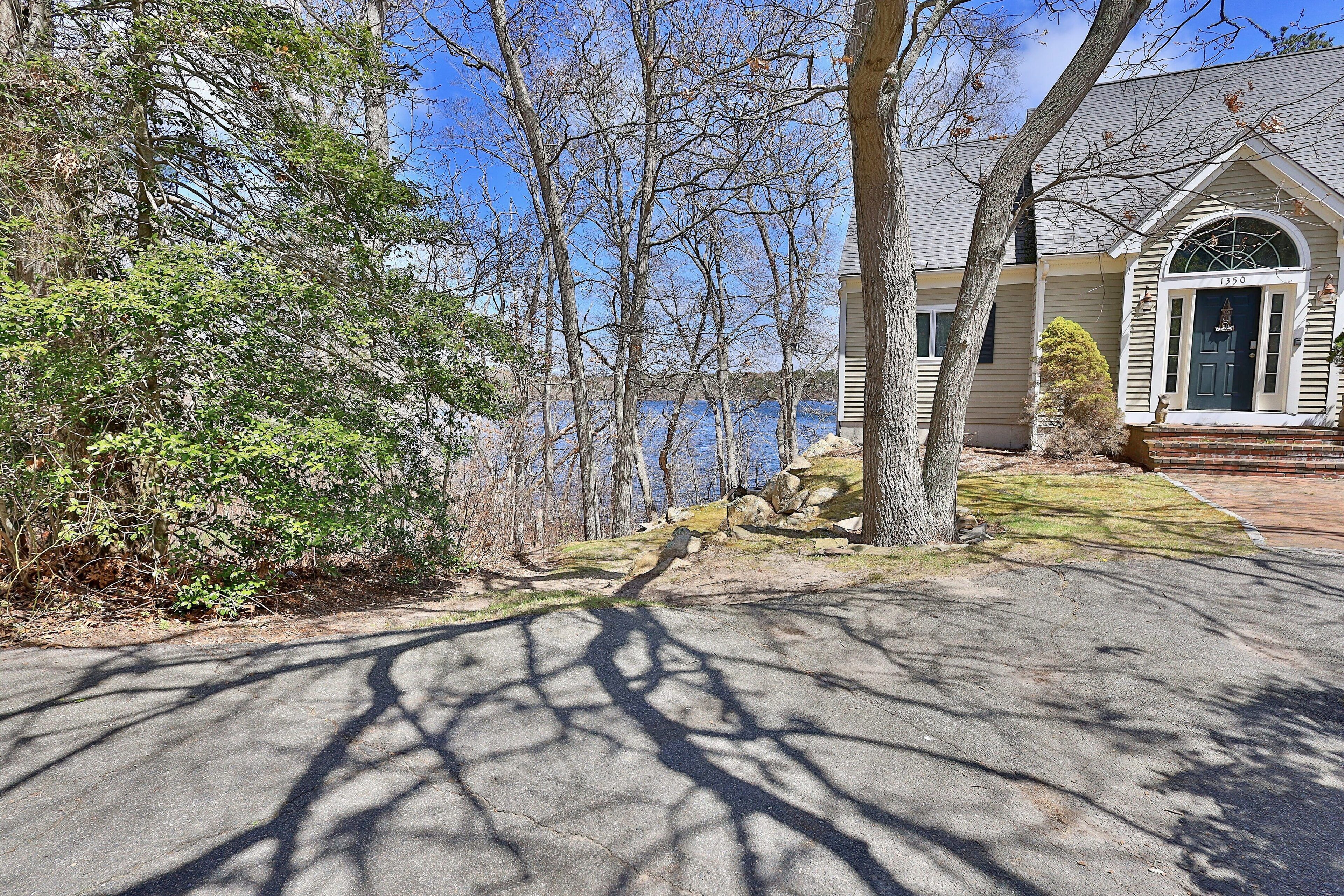 Une maison avec un porche à l’avant, une boîte aux lettres et une vue sur un lac.