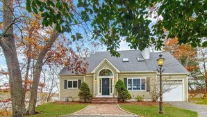 A two-story house with a front entrance, a garage, and a driveway.