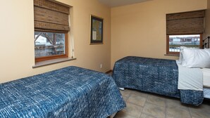 A small, clean room with two beds, a ceiling fan, and windows with blinds. - A Suite Place .5 mi from Beach (Michigan City)