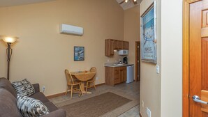 A compact living space with a kitchenette, a dining area, and a sofa.