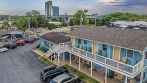 A motel with a two-story structure, a parking lot, and a bridge in the background. - A Suite Place .5 mi from Beach (Michigan City)