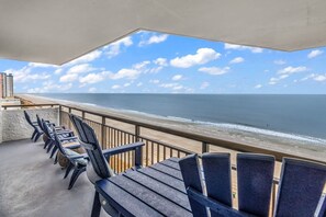 A balcony with chairs overlooking a beach and ocean. - Bluewater Resort 903 (Myrtle Beach)