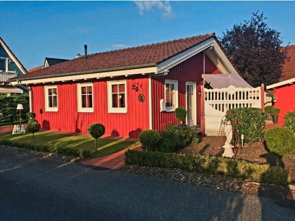A red house with a white fence, a small garden, and a clear sky. - Red Swedish house pet friendly! (Haselünne)