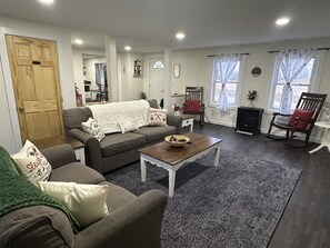 Uma sala de estar acolhedora com um sofá, uma mesa de centro e uma lareira.