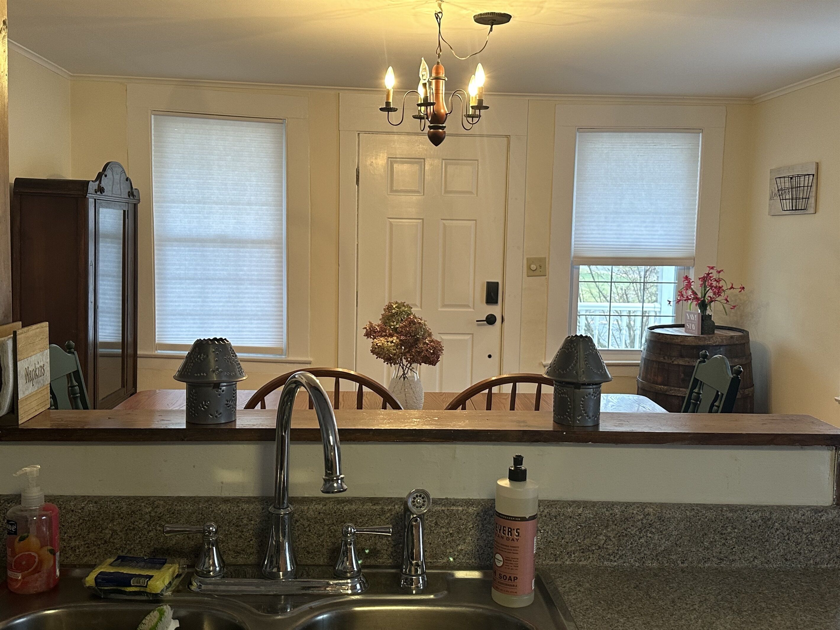 A kitchen with a double sink, a chandelier, and a wooden countertop.