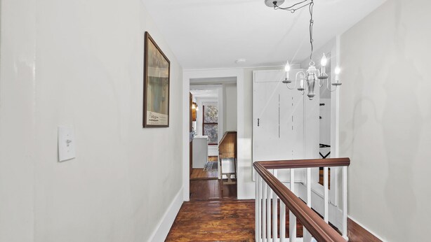 A hallway with white walls, a wooden staircase, and a chandelier. - *NEW*Hops House-Sleeps10-8Mi.toCDP&15Mi.toASV (Hartwick)