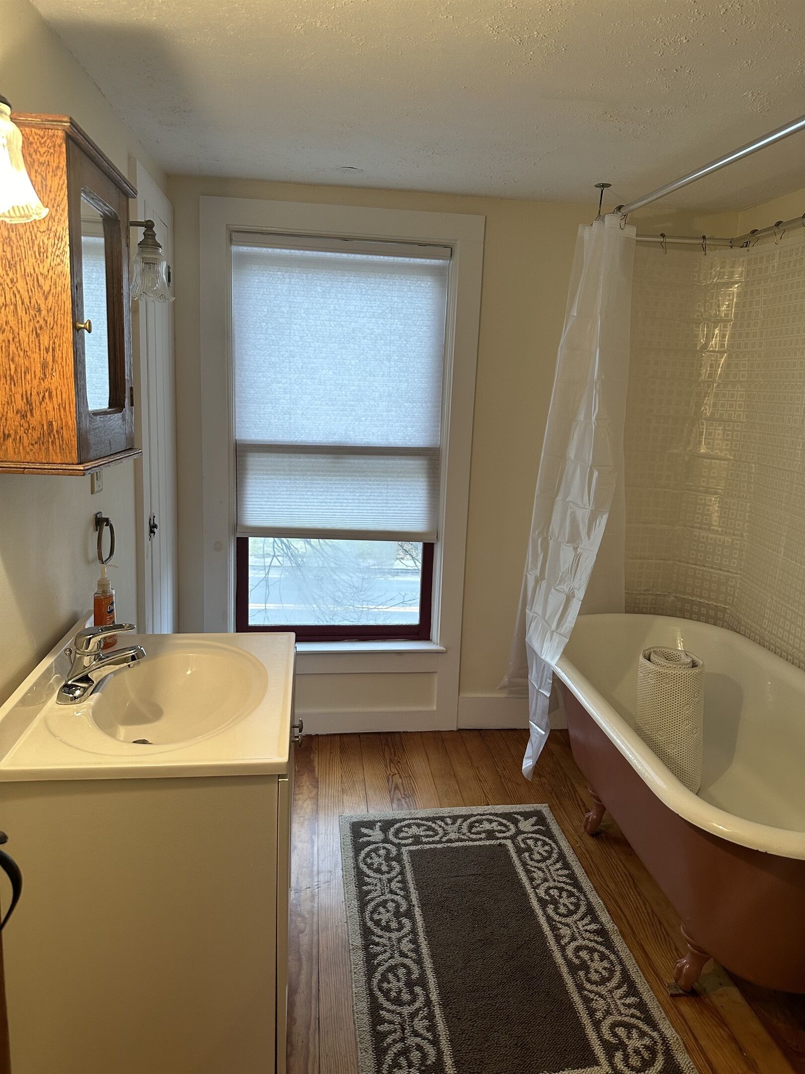 Un baño con lavamanos, ventana y bañera.