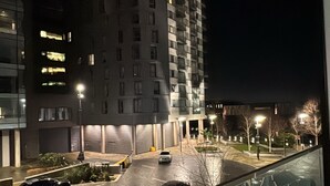 Vista nocturna de un edificio moderno con varios pisos y ventanas iluminadas.