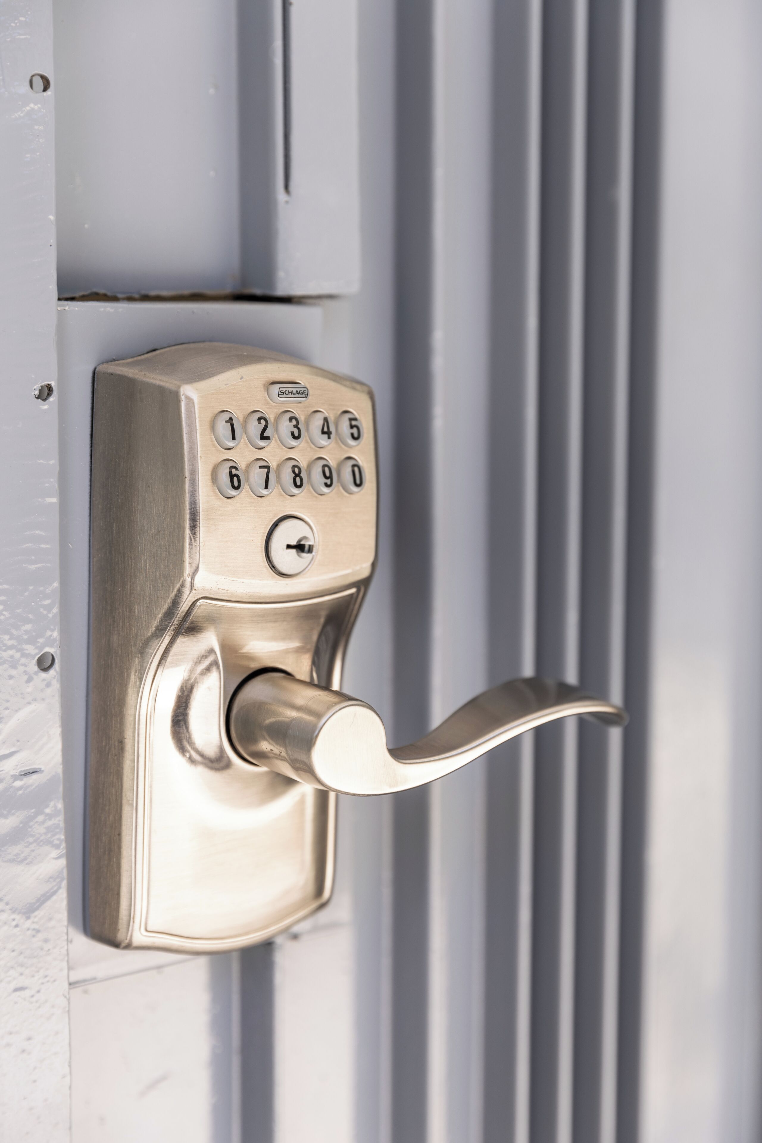 A modern door lock with a numeric keypad and a lever handle.